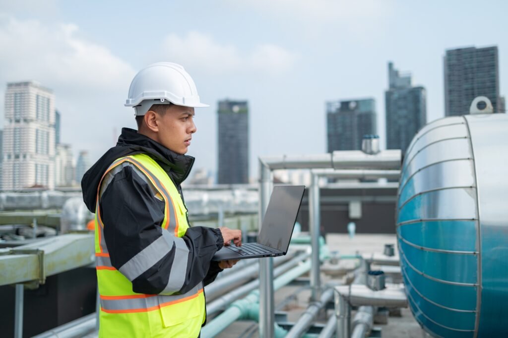 Engineer inspects water heater pump system and hot water tank on industrial roof